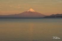 O magnífico vulcão Osorno e o lago Llanquihue iluminados pela luz de fim de tarde, em Puerto Varas, no sul do Chile